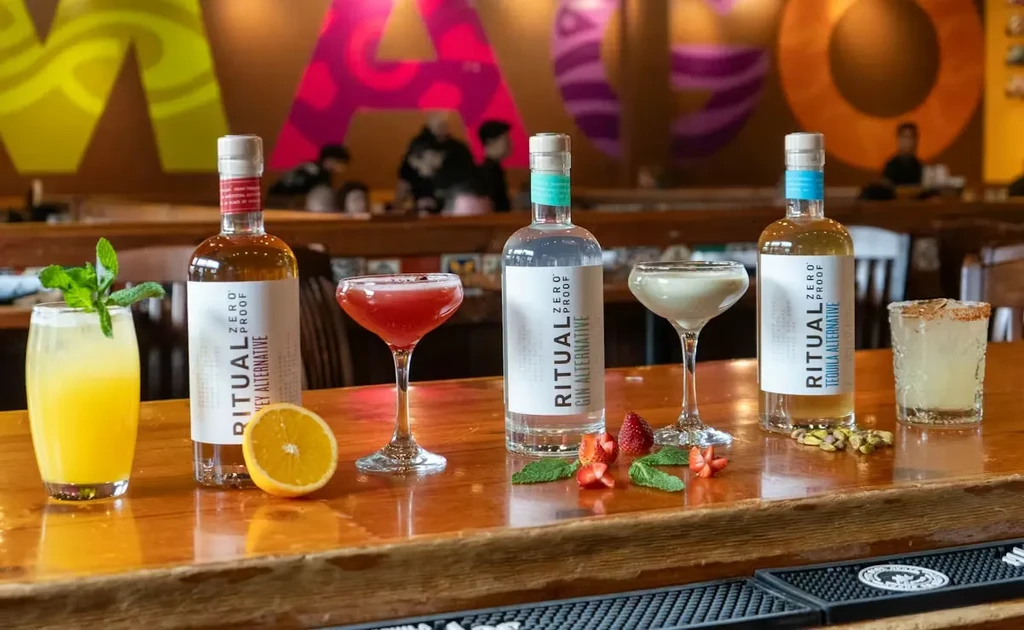 Ritual Zero Proof bottles and cocktails on a wooden bar.