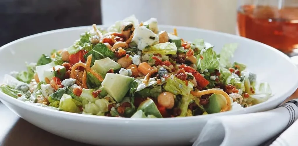 Close-up, high-angle shot of a vibrant, colorful salad in a white bowl.