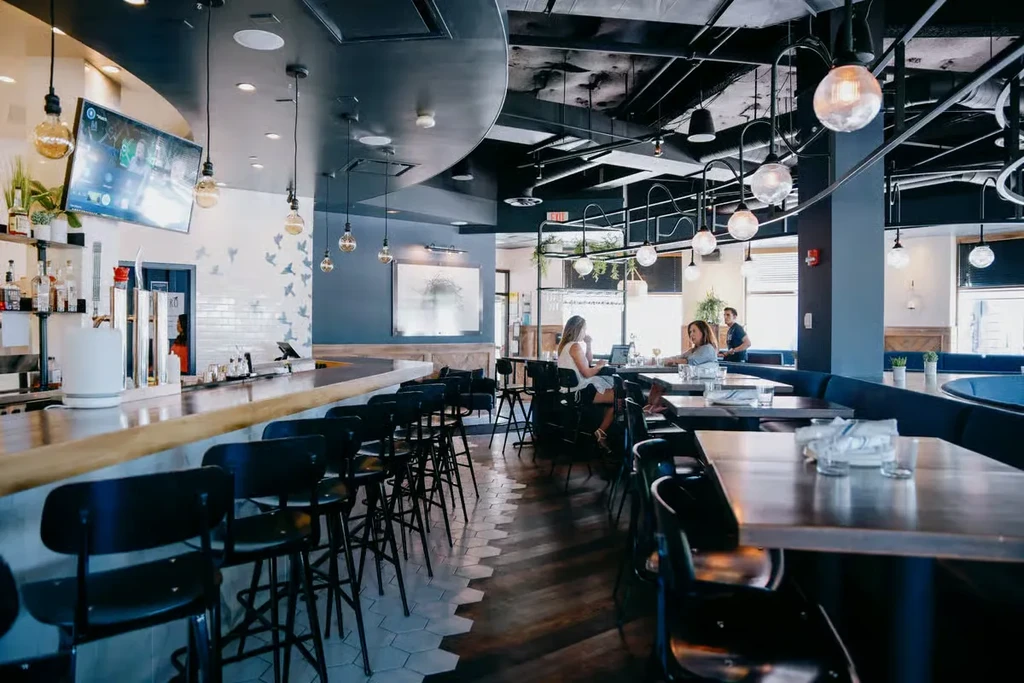 Modern restaurant interior with a long bar and dining area.