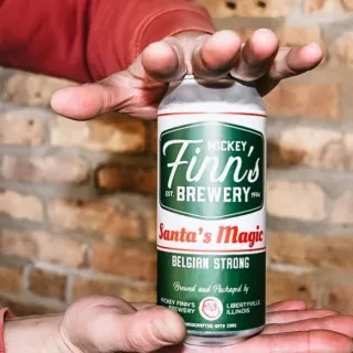 Close-up of hands holding a Mickey Finn's Santa's Magic beer can.