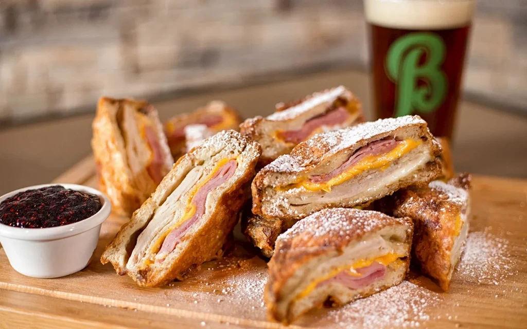 Crispy Monte Cristo sandwiches, powdered sugar, berry jam, and dark beer.