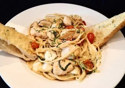 Pasta with chicken, tomatoes, mozzarella, herbs, and garlic bread.