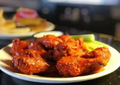 Buffalo chicken wings, white dipping sauce, and celery sticks.