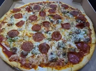 Whole pepperoni, sausage, pepper, onion pizza in a cardboard box.