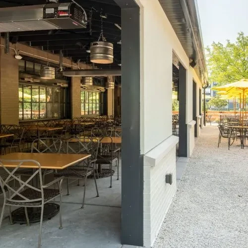 Empty restaurant with industrial-style indoor and outdoor patio seating.