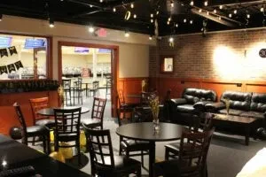 Empty restaurant interior with diverse seating, string lights, and event decor.