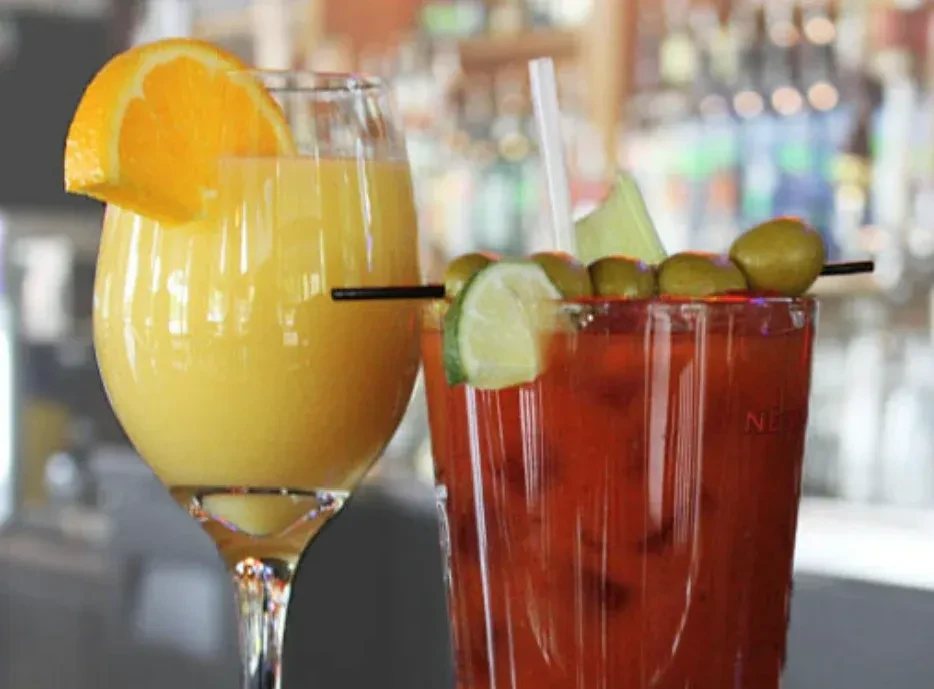 A golden mimosa and a heavily garnished red Bloody Mary.