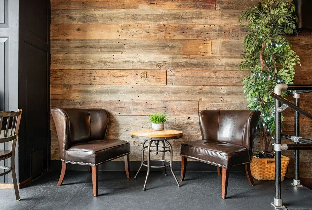 Two studded leather chairs at an industrial table in a rustic restaurant.