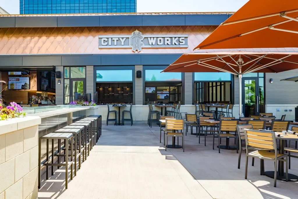 Modern City Works restaurant exterior with empty outdoor patio and bar.