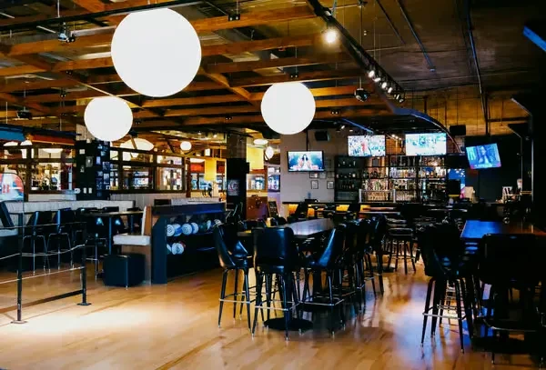 Modern gastropub interior with bar, high-top tables, and bowling balls.