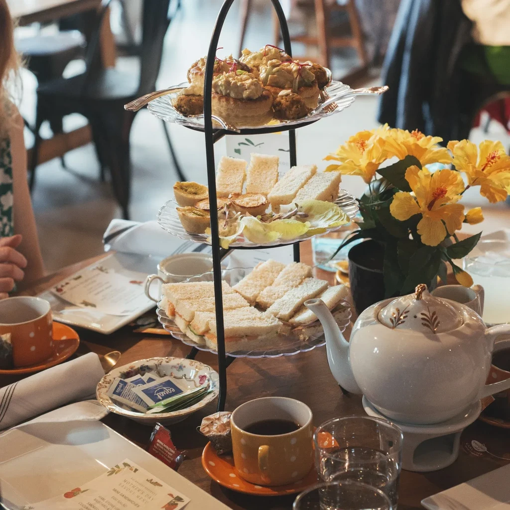Afternoon tea with a three-tiered stand of savories and sweets.