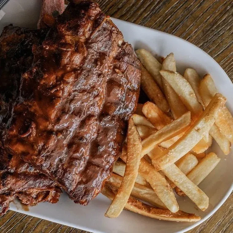 Plate with barbecue ribs and a side of french fries.