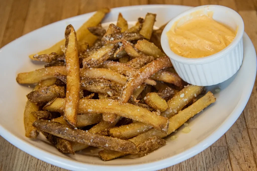 Hand-cut french fries with Parmesan cheese and dipping sauce.