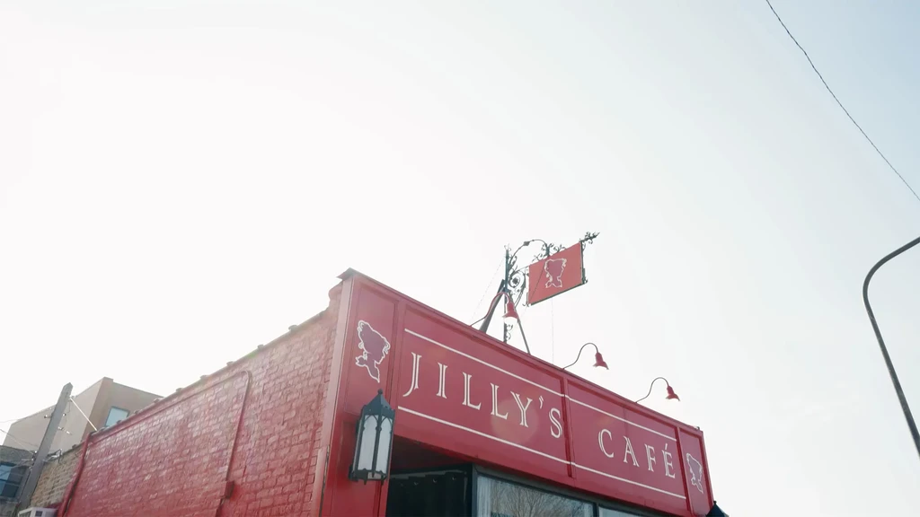 Exterior of JILLY'S CAFÉ building with red facade and signs.