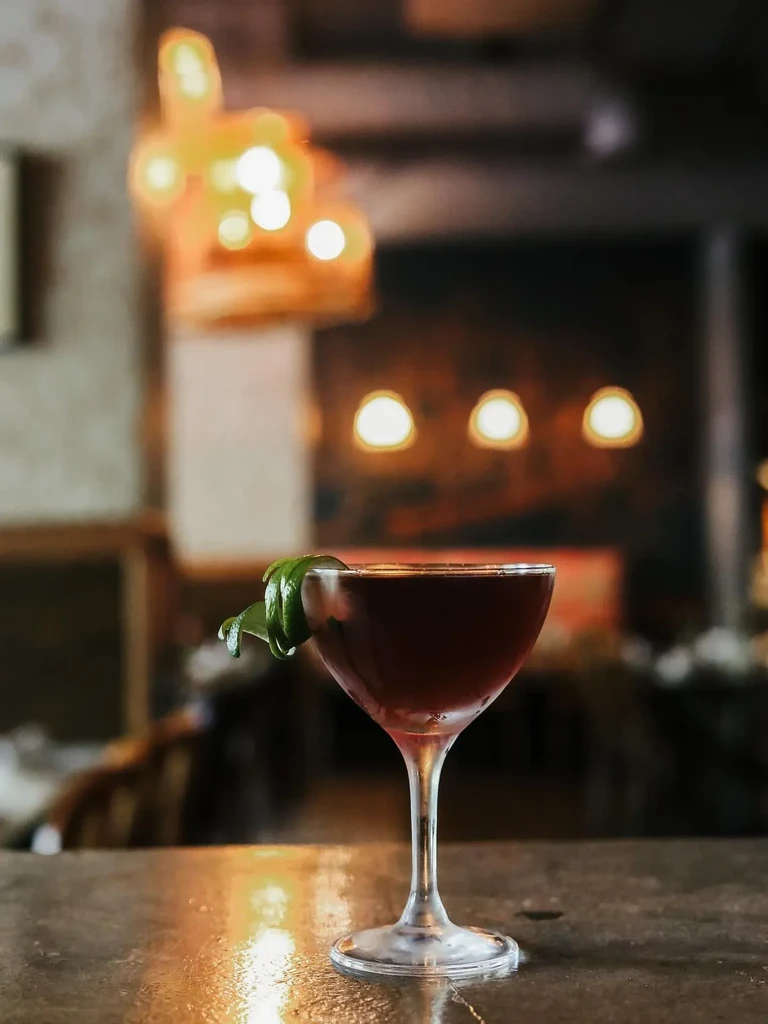Cocktail in a coupe glass with a lime peel garnish.