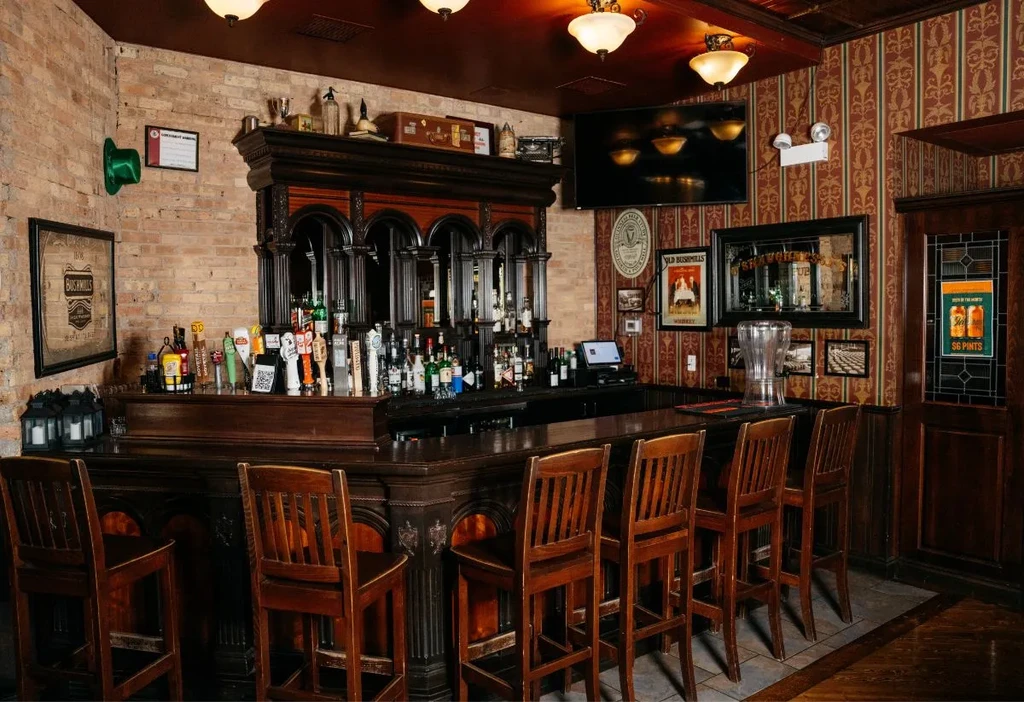 Interior of a traditional, ornate bar with a wide selection of liquor.