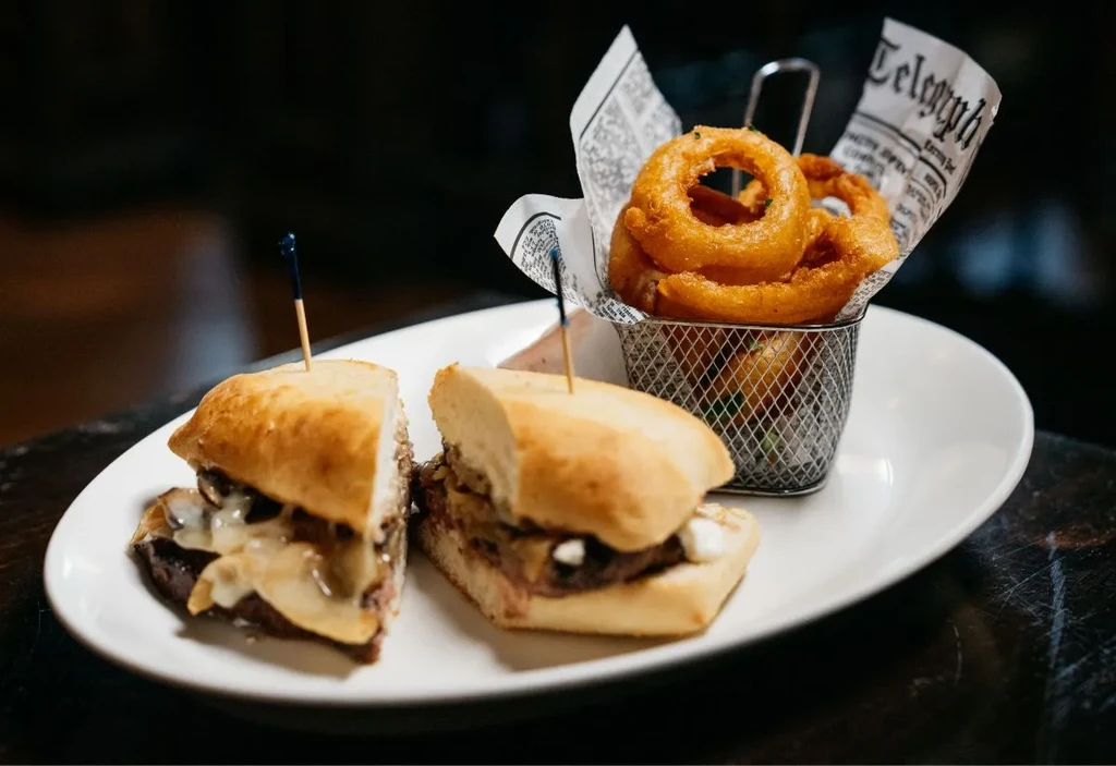 Sandwich halves with melted cheese, and onion rings.