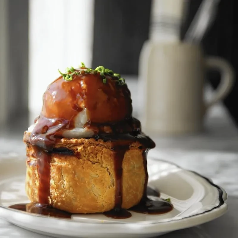 Golden-brown pastry with ice cream, caramel sauce, and green herbs.