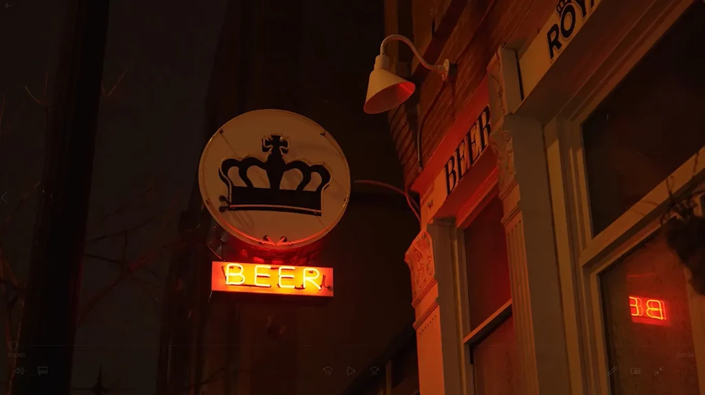 Neon "BEER" sign below a crown symbol on a building.