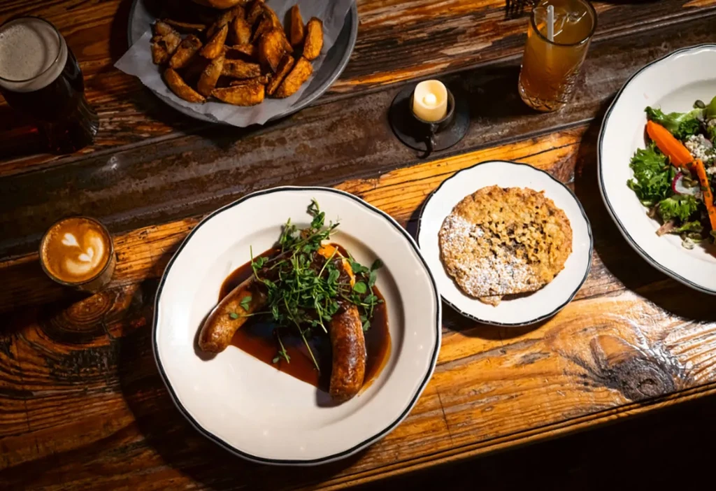 Overhead shot of a rustic table with plates of food and drinks.