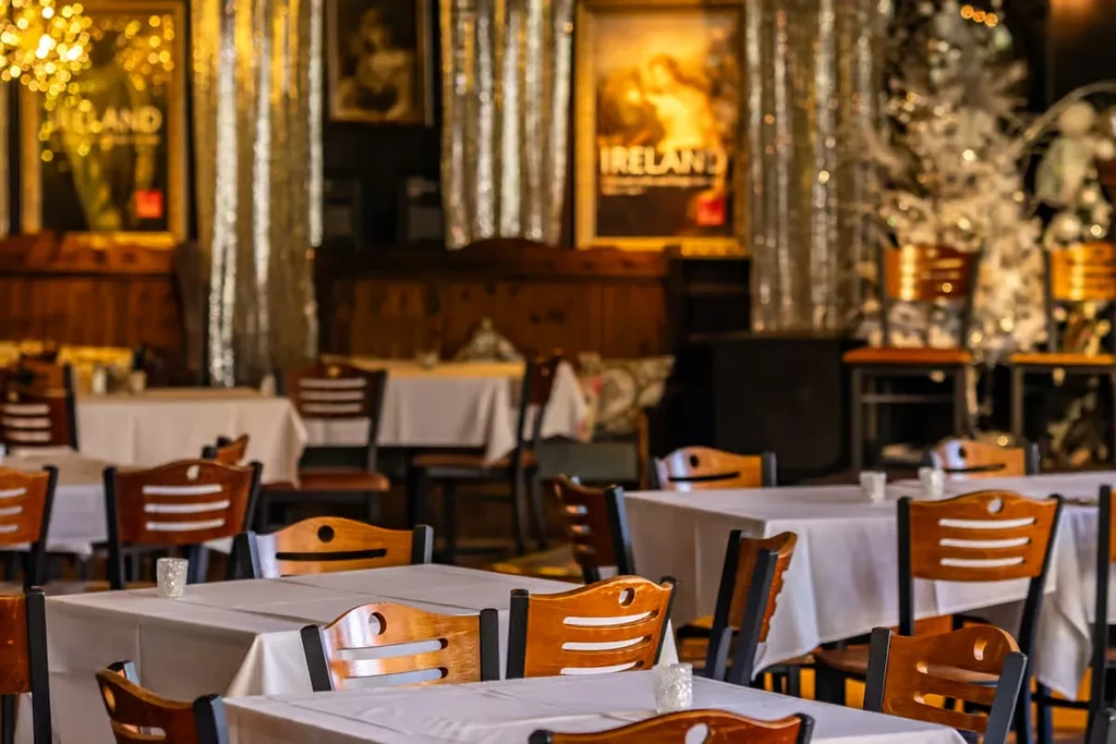 Restaurant interior with set tables, chairs, and "IRELAND" poster.