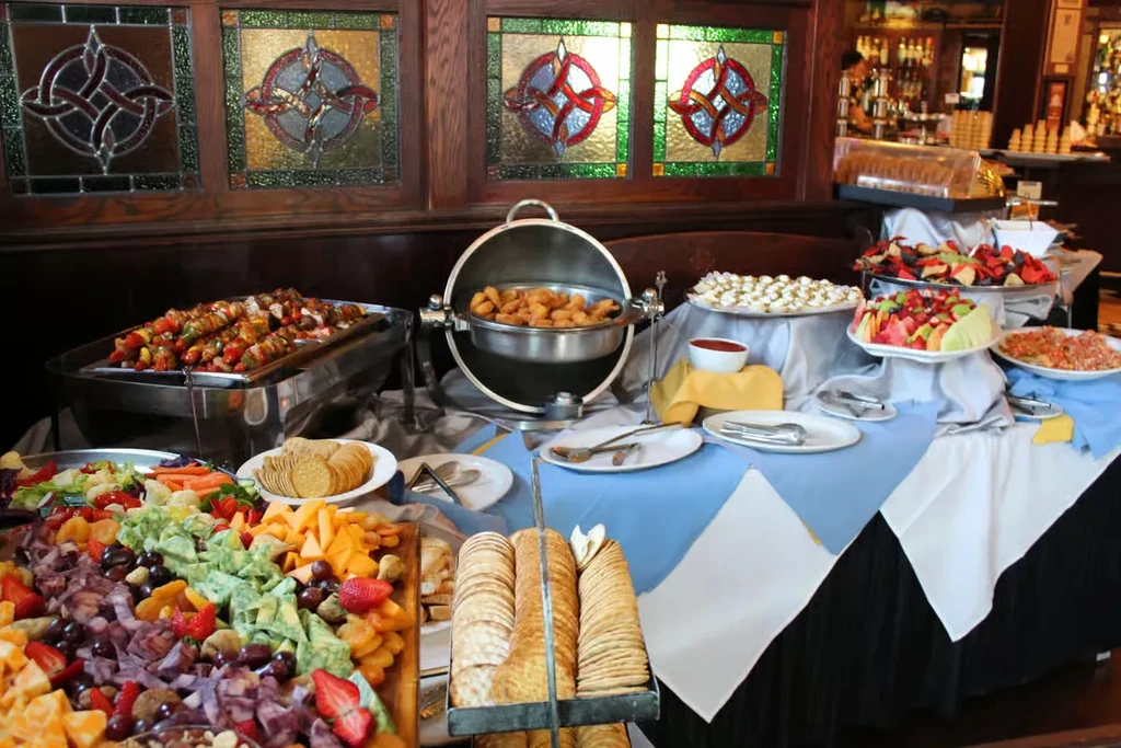 Buffet table with cheese, fruit, skewers, and other appetizers.