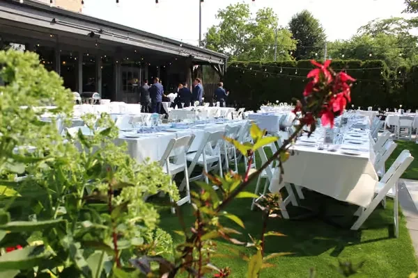 Outdoor restaurant setting with tables, chairs, and string lights.