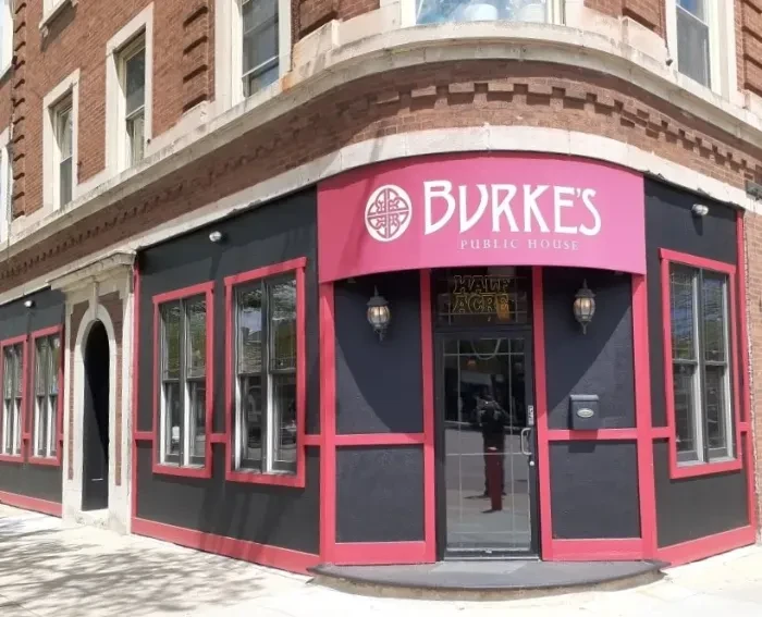 Exterior of Burke's Public House, a brick building with a pink awning.
