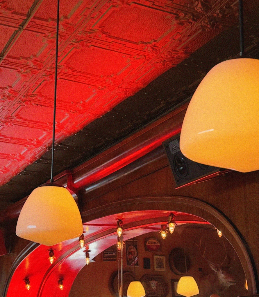 Restaurant interior with a pressed tin ceiling and warm lighting.
