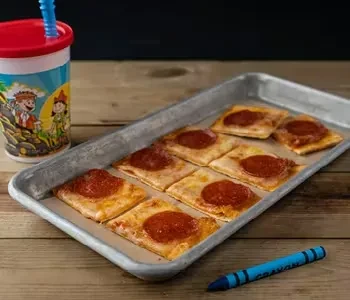 Eight square pizzas on a tray, a cup, and a crayon.