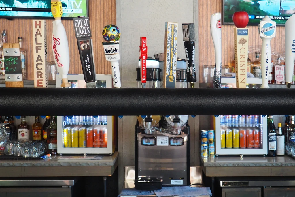 Beer taps, TVs, and drinks at a well-stocked bar.