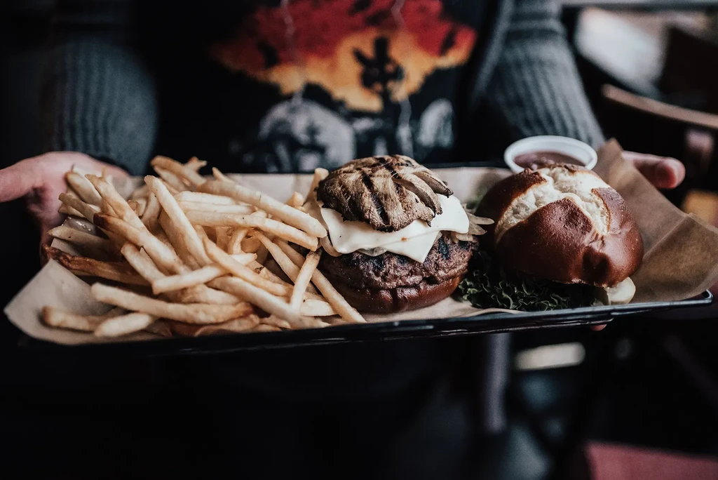 Two burgers, french fries, and sauce on a tray.