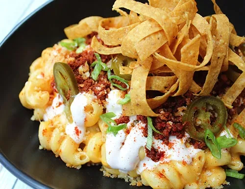 Macaroni and cheese with meat, sour cream, jalapeños, and tortilla strips.