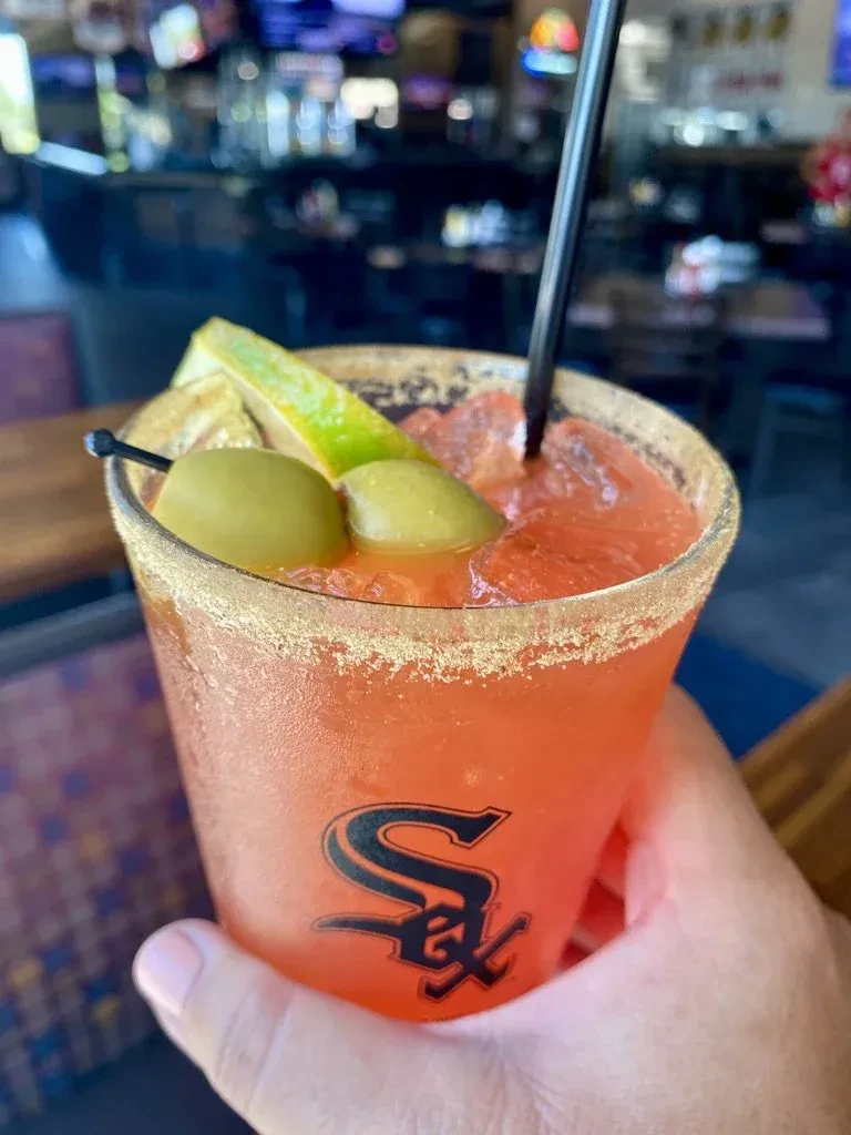 Reddish-orange cocktail in a Chicago White Sox plastic cup.