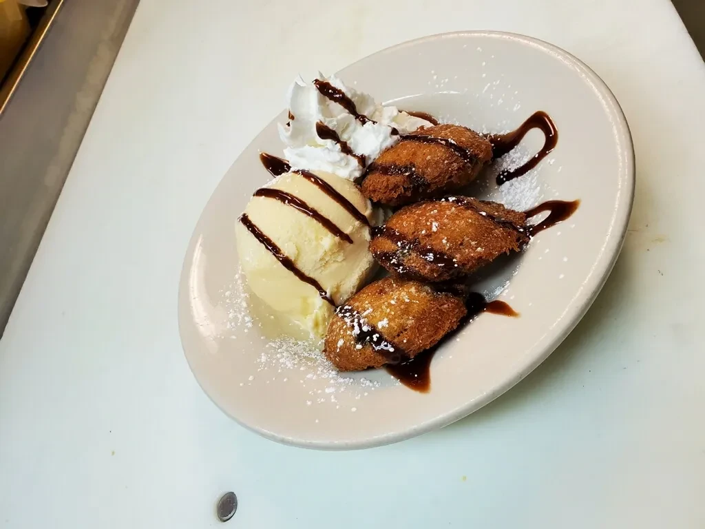 Fried dough, chocolate, powdered sugar, vanilla ice cream, whipped cream.