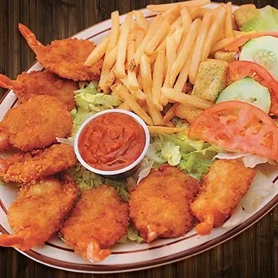 A platter of fried shrimp, golden fries, salad, and dipping sauce.