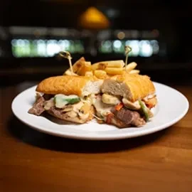 Large sub sandwich with meat, cheese, vegetables, and fries.