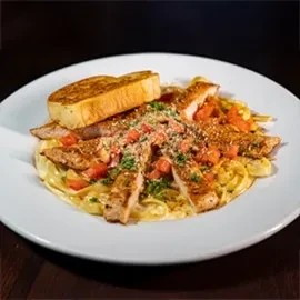 Fettuccine with chicken, cream sauce, tomatoes, herbs, and garlic bread.