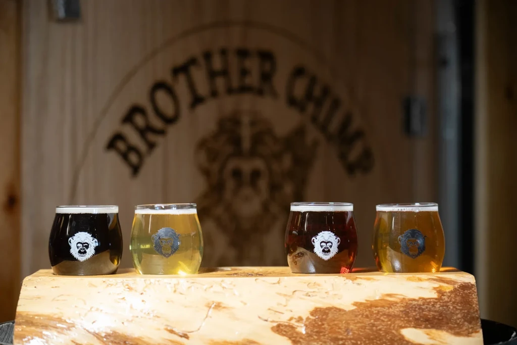 A flight of four different beers with Brother Chimp branding.