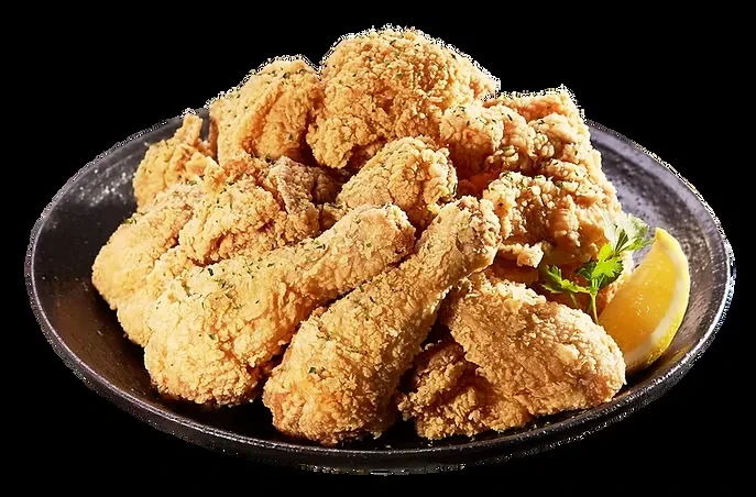 A bowl of crispy golden-brown fried chicken with lemon and herbs.
