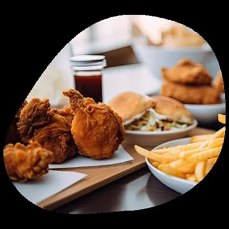 Crispy fried chicken, golden fries, and a slider on a dark table.