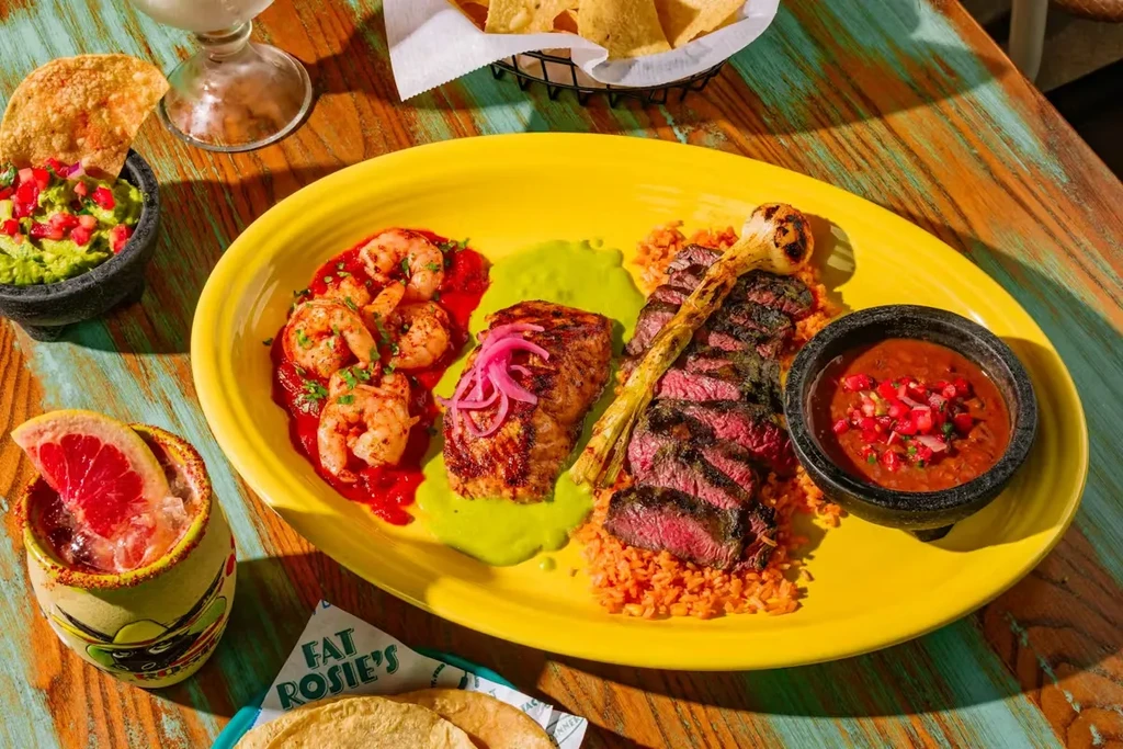 Vibrant overhead shot of Mexican food, drinks, guacamole, and salsa.