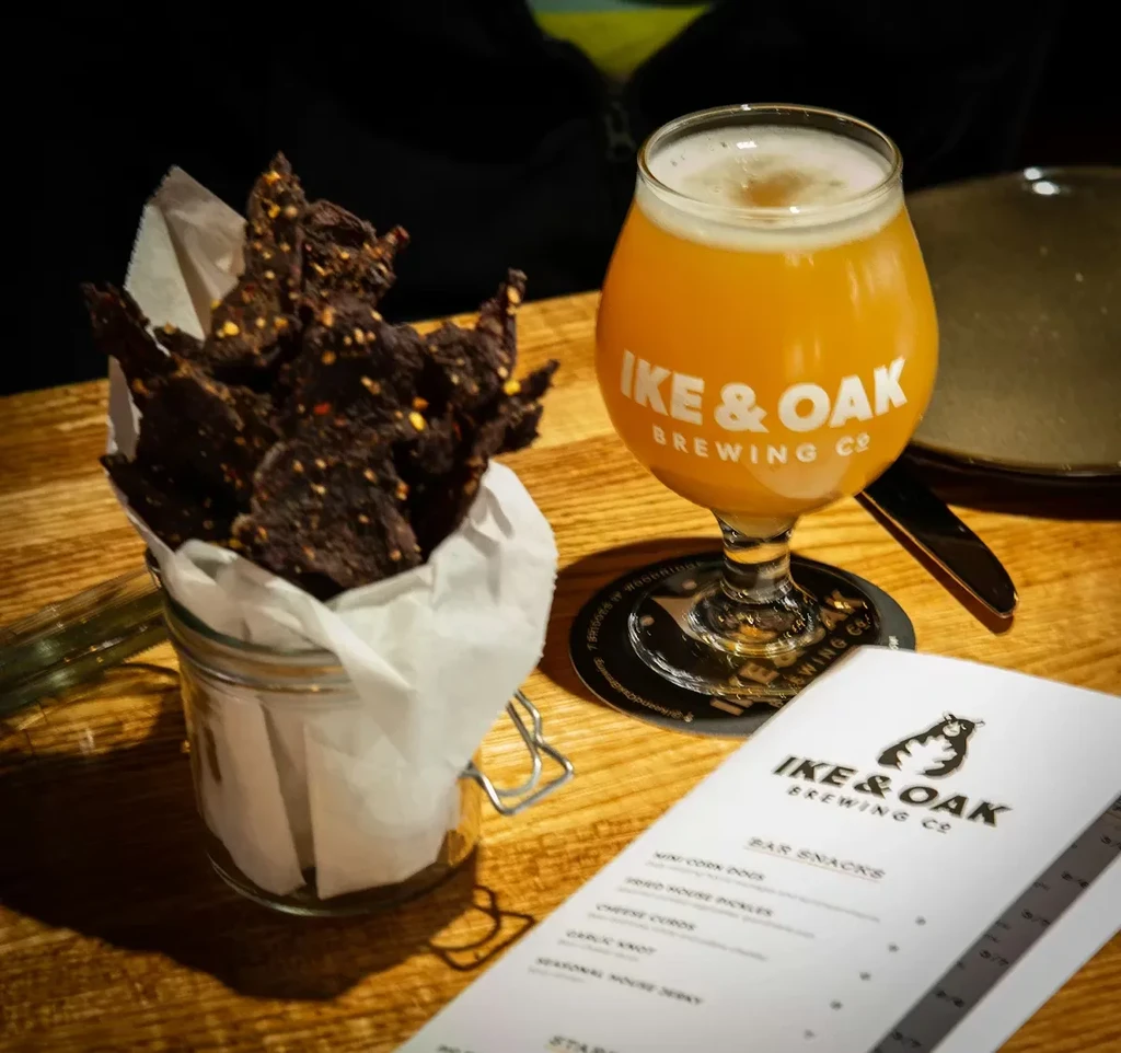 Overhead shot of beer, jerky, and menu at Ike & Oak Brewing.