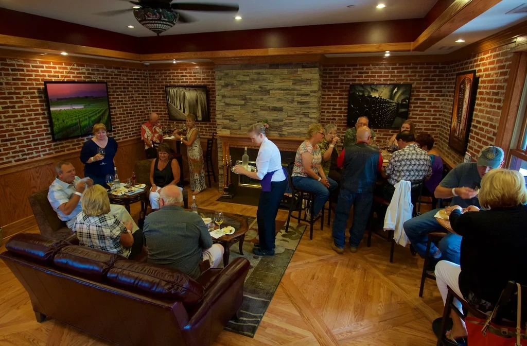 Lively restaurant interior with brick walls, fireplace, and many socializing patrons.