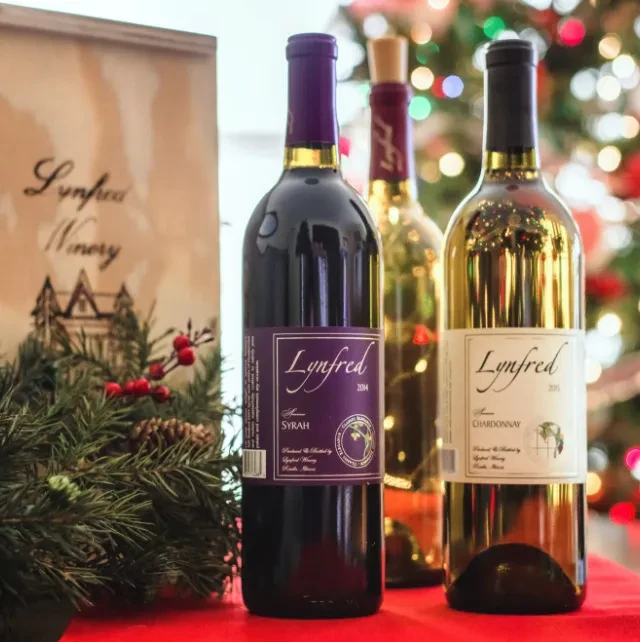 Three Lynfred Winery wine bottles with holiday decorations.