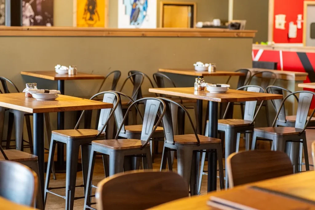 Empty high-top tables and chairs set in a casual restaurant.