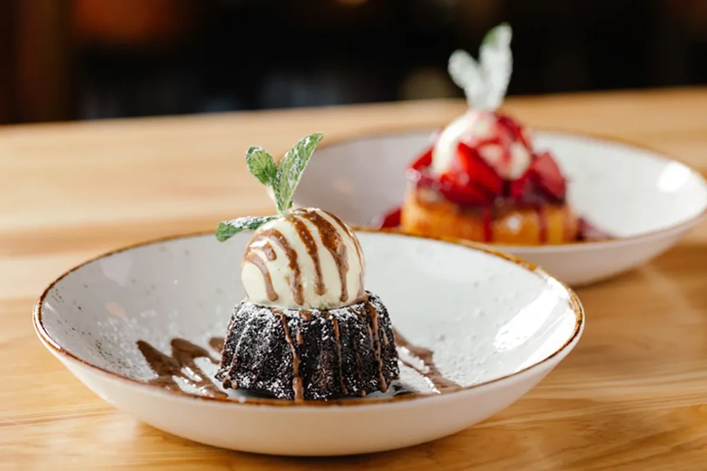 Chocolate lava cake with ice cream, mint; blurred strawberry cake.