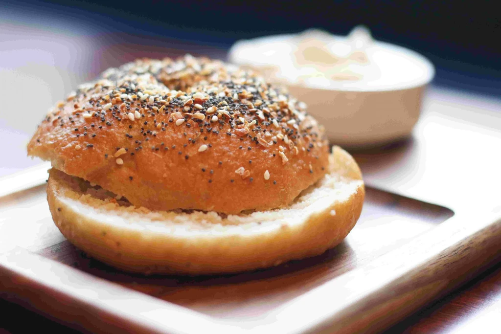 Everything bagel, sliced with filling, on a serving board.