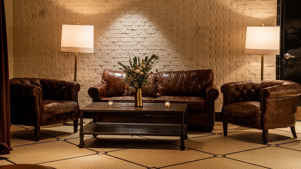 Tufted leather armchairs and sofa around a coffee table.