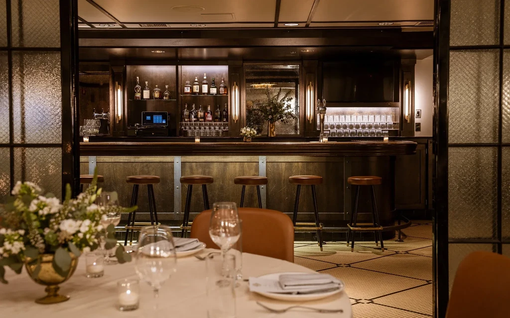 Upscale bar and dining room with white table cloths.